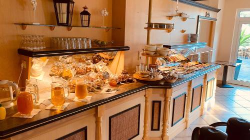 a kitchen with a counter with food on it at Hotel Dünenschloss in Ostseebad Karlshagen