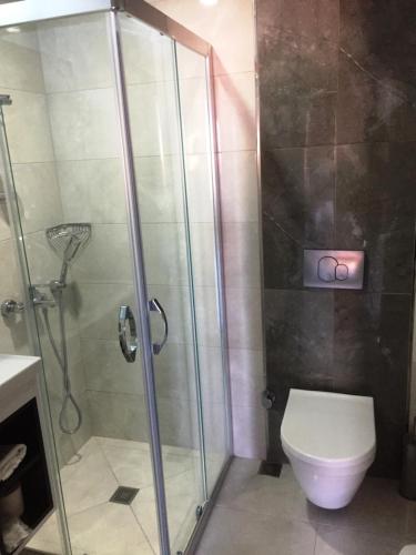 a bathroom with a shower and a toilet at Hotel Baylan İzmir in Izmir