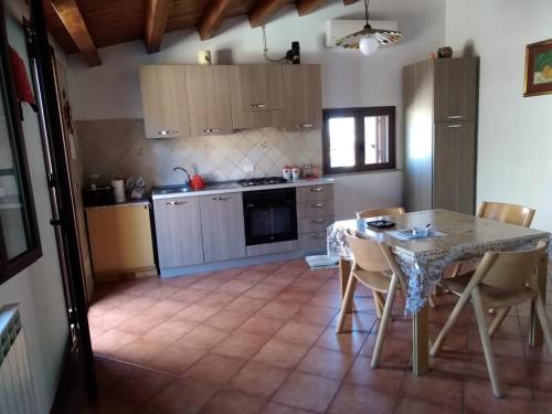 a kitchen with a table and chairs and a kitchen with a stove at Casa Levante in Castelbuono