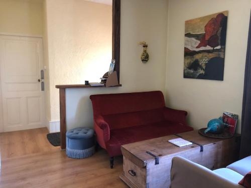 a living room with a red couch and a table at appartement Saint-Antoine in Toulon-sur-Arroux