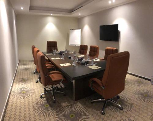 a conference room with a large table and chairs at Holiday Plus Al Salamh- هوليداي بلس السلامه in Jeddah