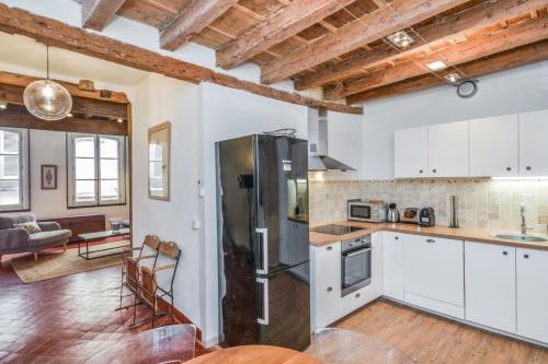 une cuisine avec un réfrigérateur et un salon dans l'établissement Appartement Gorra - Welkeys, à Avignon