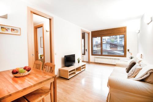 a living room with a couch and a table at Apartaments Les Terrasses del Tarter in El Tarter