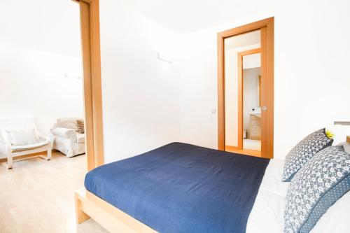 a bedroom with a bed with a blue blanket at Apartaments Les Terrasses del Tarter in El Tarter