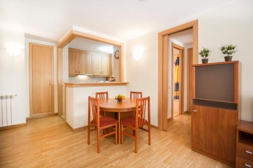 a kitchen and dining room with a table and chairs at Apartaments Les Terrasses del Tarter in El Tarter