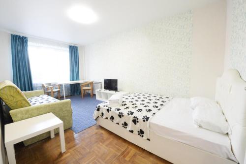 1 dormitorio con 1 cama, 1 silla y 1 mesa en Presnensky Val Apartment, en Moscú