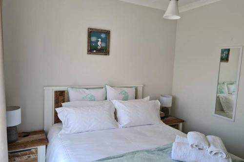 a bedroom with a white bed with white pillows at The Blyde - Little Place, Lots of Relaxation in Pretoria