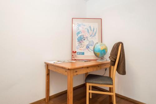 a wooden desk with a globe and a chair at Ferienwohnung Felix in Bregenz