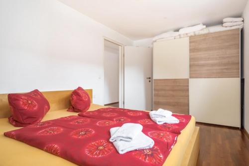 a bedroom with a red bed with towels on it at Ferienwohnung Felix in Bregenz