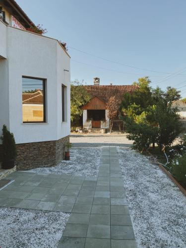 a house with a stone walkway next to a building at Pensiunea Aurelia in Şiria