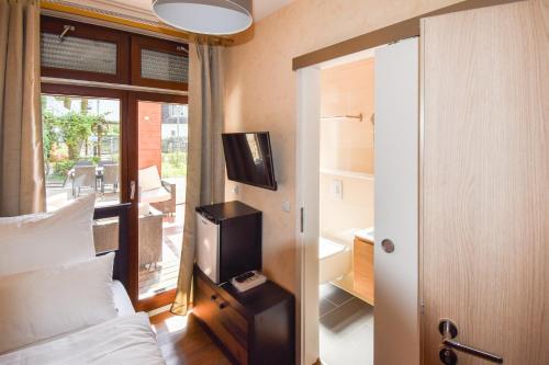 a bedroom with a bed and a tv in it at Boutique Hotel Sena in Berlin