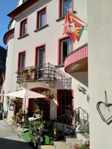 a hotel with a flag on the side of a building at Hotel Escher in Leukerbad