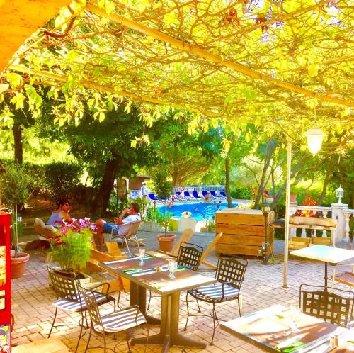 a patio with tables and chairs and a pool at LES BASTIDES DE CHANTERAINE Bungalows, Lodges & Spa in Aiguines