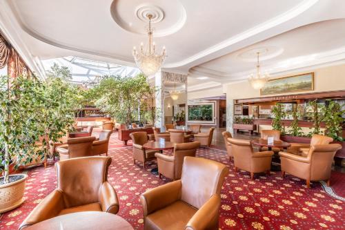 a restaurant with chairs and tables and plants at Hotel Gołębiewski Białystok in Białystok