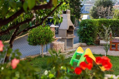 a garden with a playground with a stone oven at De Lux Apartments Luka in Bar