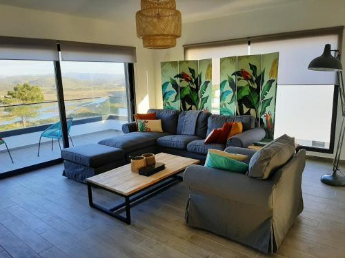 ein Wohnzimmer mit einem Sofa und einem Tisch in der Unterkunft Cairnvillas - Villa Solar C37 Luxury Villa with Swimming Pool near Beach in Aljezur