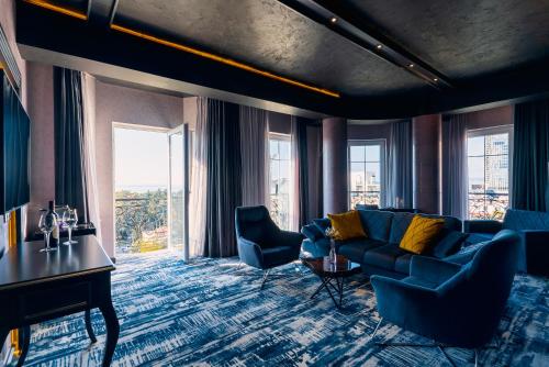 巴統的住宿－Tapis Rouge Design Boutique Hotel，客厅配有蓝色的沙发和椅子