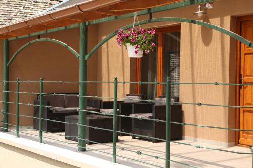 a balcony with green railing and a potted plant at Hunyadi Panzió-Apartman in Makó