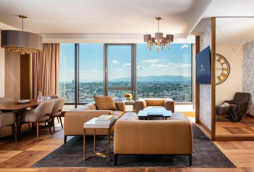 a living room with a couch and a table at Grand Hotel Millennium Sofia in Sofia