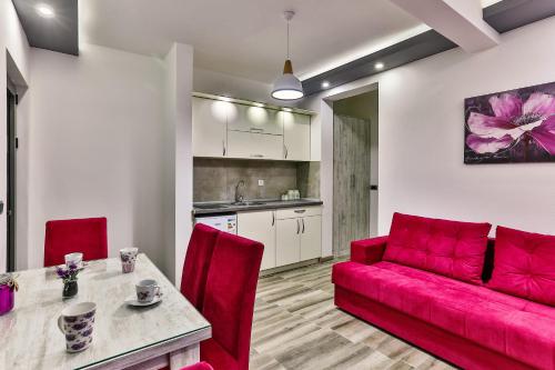 a living room with a red couch and a table at De Lux Apartments Luka in Bar