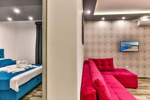 a room with a bed and a red couch at De Lux Apartments Luka in Bar