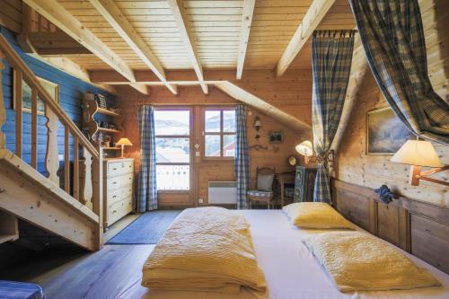 a bedroom with a large bed in a wooden room at Residence les chalets de Flaine Hameau - maeva Home in Flaine