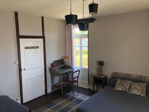 a bedroom with a bed and a desk and a window at appartement Saint-Antoine in Toulon-sur-Arroux