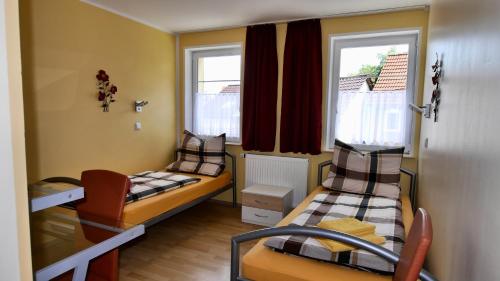 a small room with two beds and a window at Pension Metilstein in Eisenach