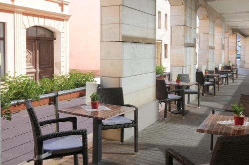 a row of tables and chairs on a patio at martas Hotel Lutherstadt Wittenberg in Lutherstadt Wittenberg