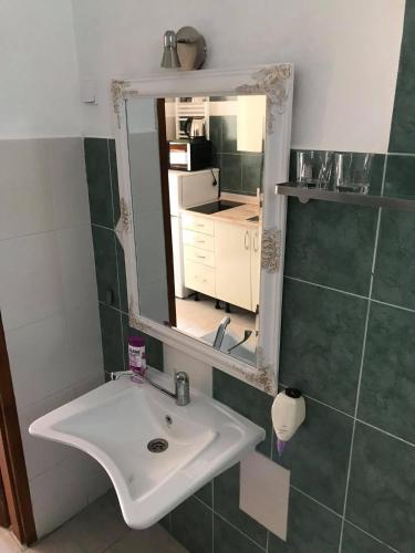 a bathroom with a sink and a mirror at Hunyadi Panzió-Apartman in Makó