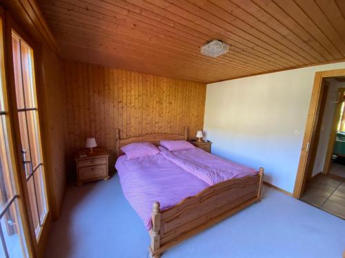 um quarto com uma cama num quarto de madeira em Sorgenfrei em Schwarzsee