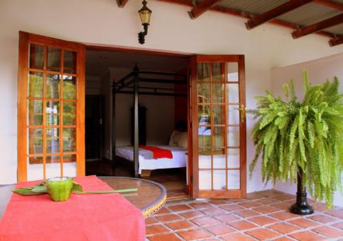 a room with a table and a bedroom with a bed at Orange-Ville Lodge & Guesthouse in Stellenbosch