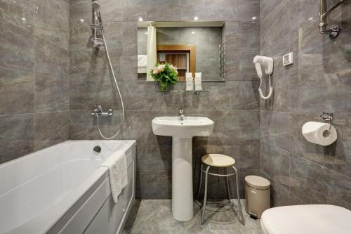 uma casa de banho com um lavatório, uma banheira e um WC. em Park Tower em Moscovo