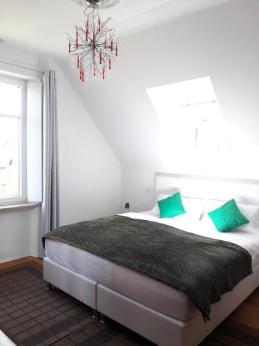 Schlafzimmer mit einem Bett mit grünen Kissen und einem Kronleuchter in der Unterkunft Bismarckstrasse 8 in Bad Bergzabern