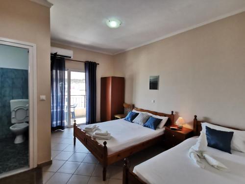 a hotel room with two beds and a bathroom at Brb rooms in Himare