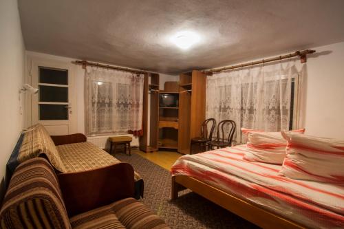 a bedroom with two beds and a couch in it at Pensiunea Schneider in Covasna