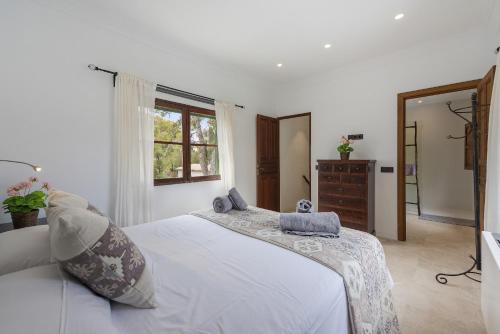 a bedroom with a white bed and a window at Stunning Villa C'an Payeras in Port de Pollensa