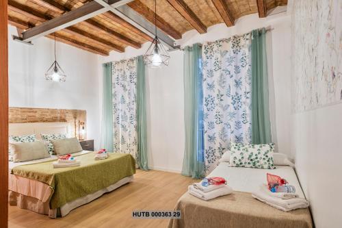 1 dormitorio con 2 camas y cortinas en Alcam Gignas en Barcelona