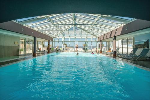 a large swimming pool in a large building at Résidence Pierre & Vacances Premium Le Coteau et la Mer in Tréboul