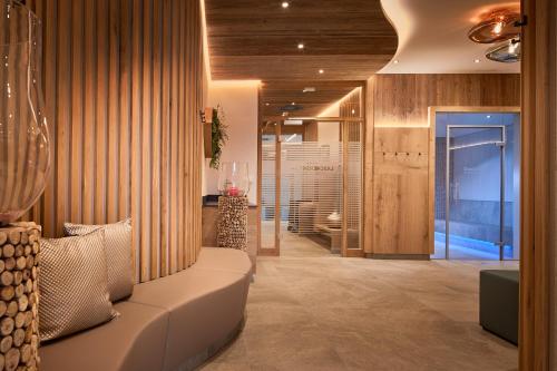 Laschenskyhof Hotel & Spa في فالس: غرفة معيشة مع أريكة بيضاء وجدران خشبية
