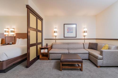 a hotel room with a couch and a bed at Hyatt Place Charleston Airport / Convention Center in Charleston