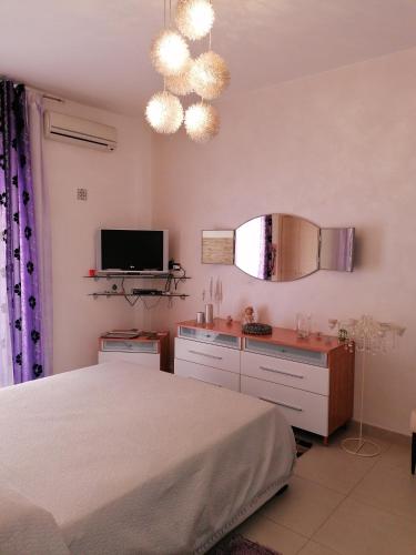 a bedroom with a bed and a flat screen tv at Cappuccini in Ragusa