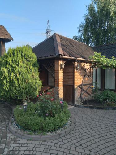 una casa de ladrillo con un jardín delante de ella en Хостел 24 en Khmelʼnytsʼkyy