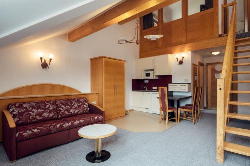 a living room and kitchen with a couch and a table at Hotel Restaurant Claudia - inklusive SUPER SOMMER CARD in Serfaus