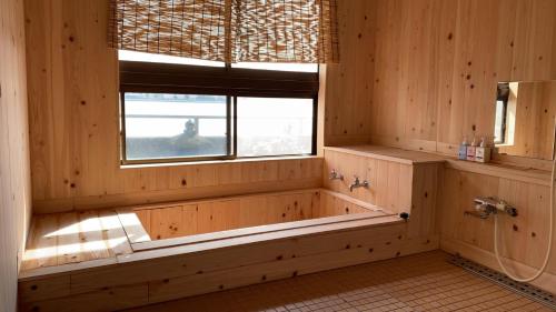 a wooden bathroom with a tub and a window at Riverside Hotel Karatsu Castle in Karatsu