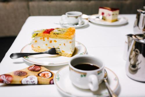 a table with a piece of cake and a cup of coffee at Hotel Restaurant Claudia - inklusive SUPER SOMMER CARD in Serfaus