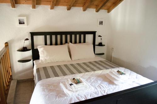 a bedroom with a bed with two towels on it at Kalokairi Cottage in Skopelos Town