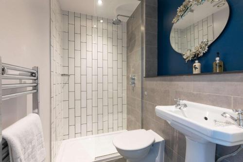 bagno con lavandino, servizi igienici e specchio di The Station Hotel a Londra