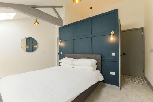 a bedroom with a large bed with a blue headboard at Goodstay Apartments by Urban Space in Barry