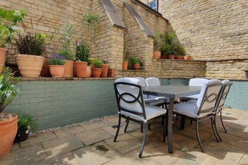 a table and chairs on a patio with potted plants at Stylish Stamford Central, Free Parking in Stamford